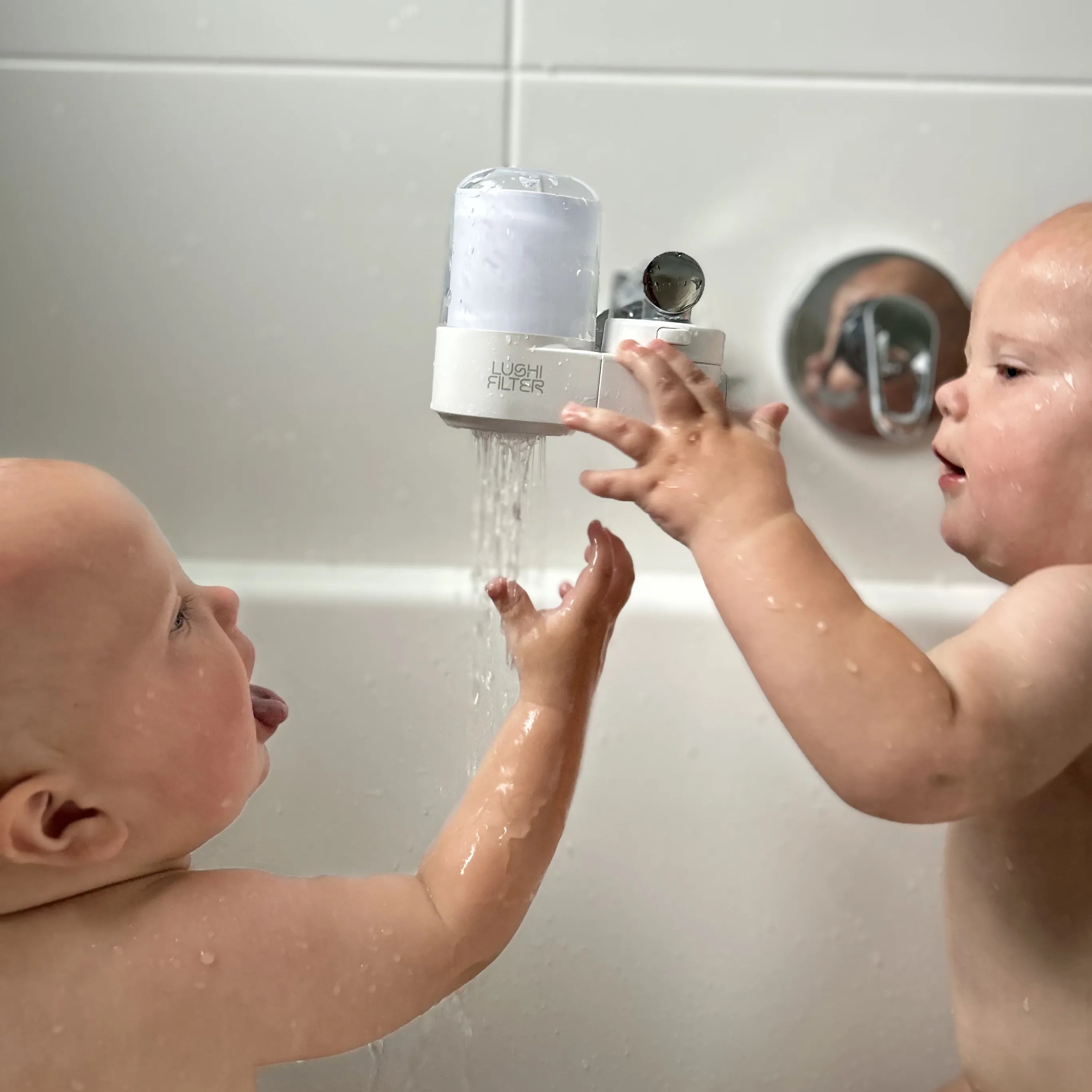Twin babies in bath tub bathing with Lushi Filter Tap & Bath Water Filter